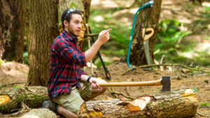 A camper chopping wood.