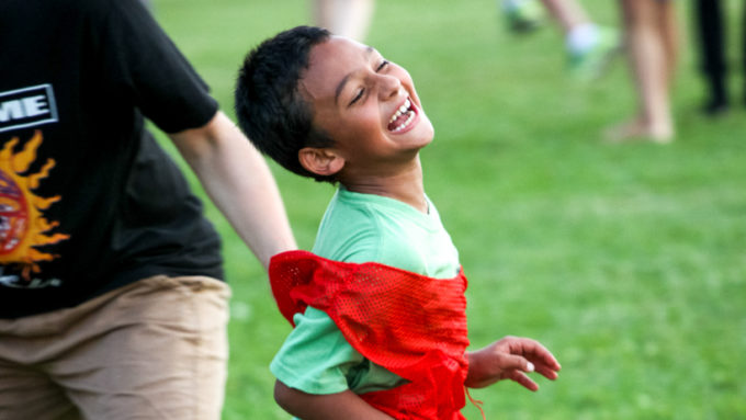 A camper running and smiling.