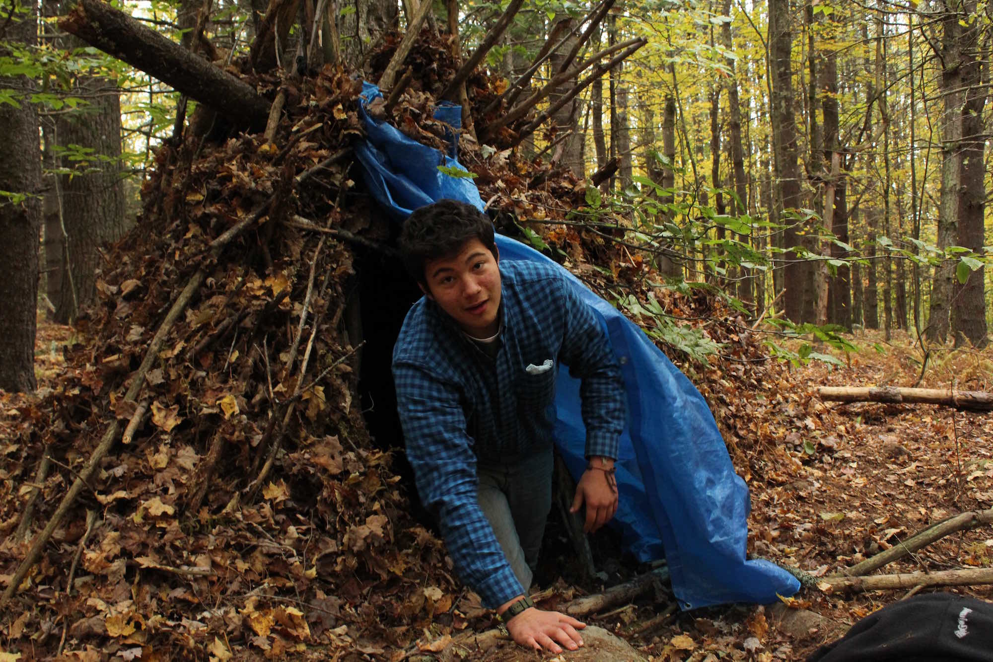 Sam emerging from his debris hut, built in anticipation of his 24-hour solo