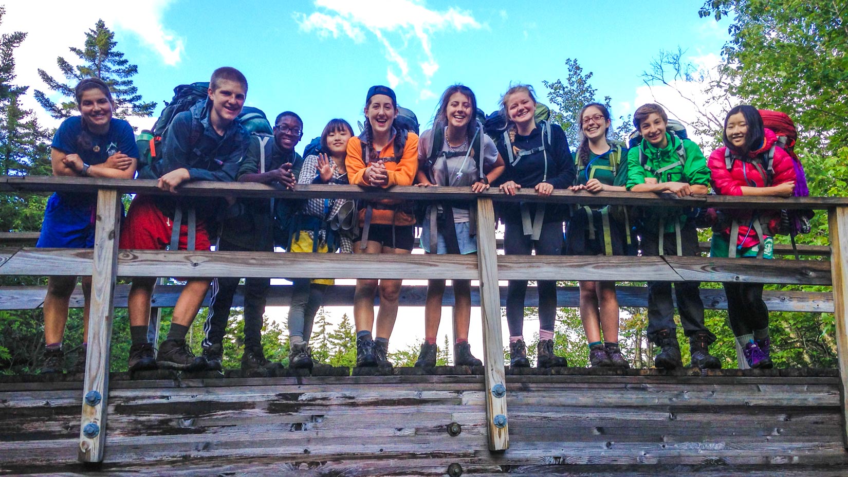 Campers on a bridge smiling at the camera
