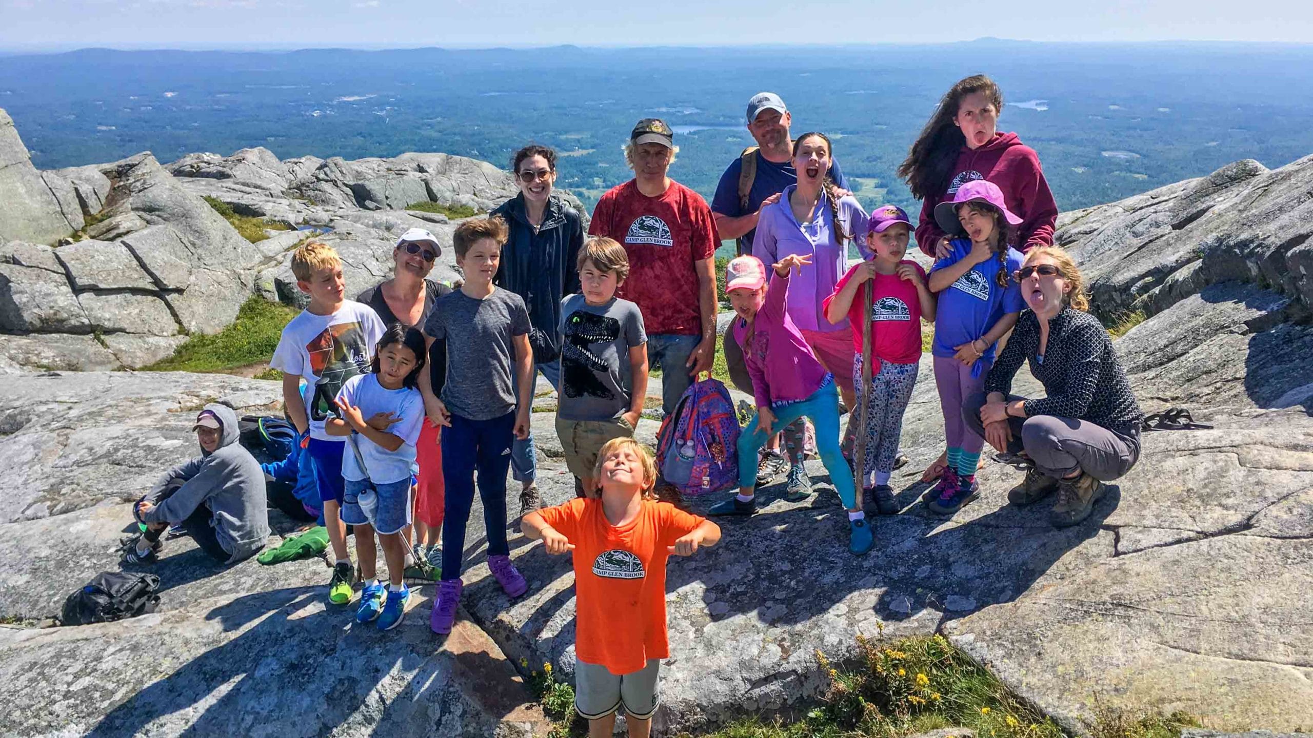 A group of family campers hiking on a mountain.