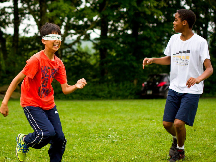 Campers running in a green field.