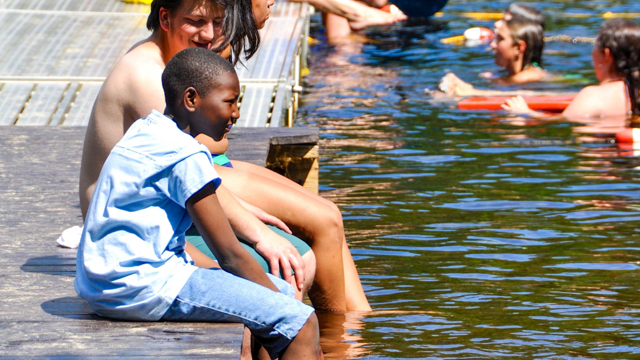 Campers sitting on the dock and talking.
