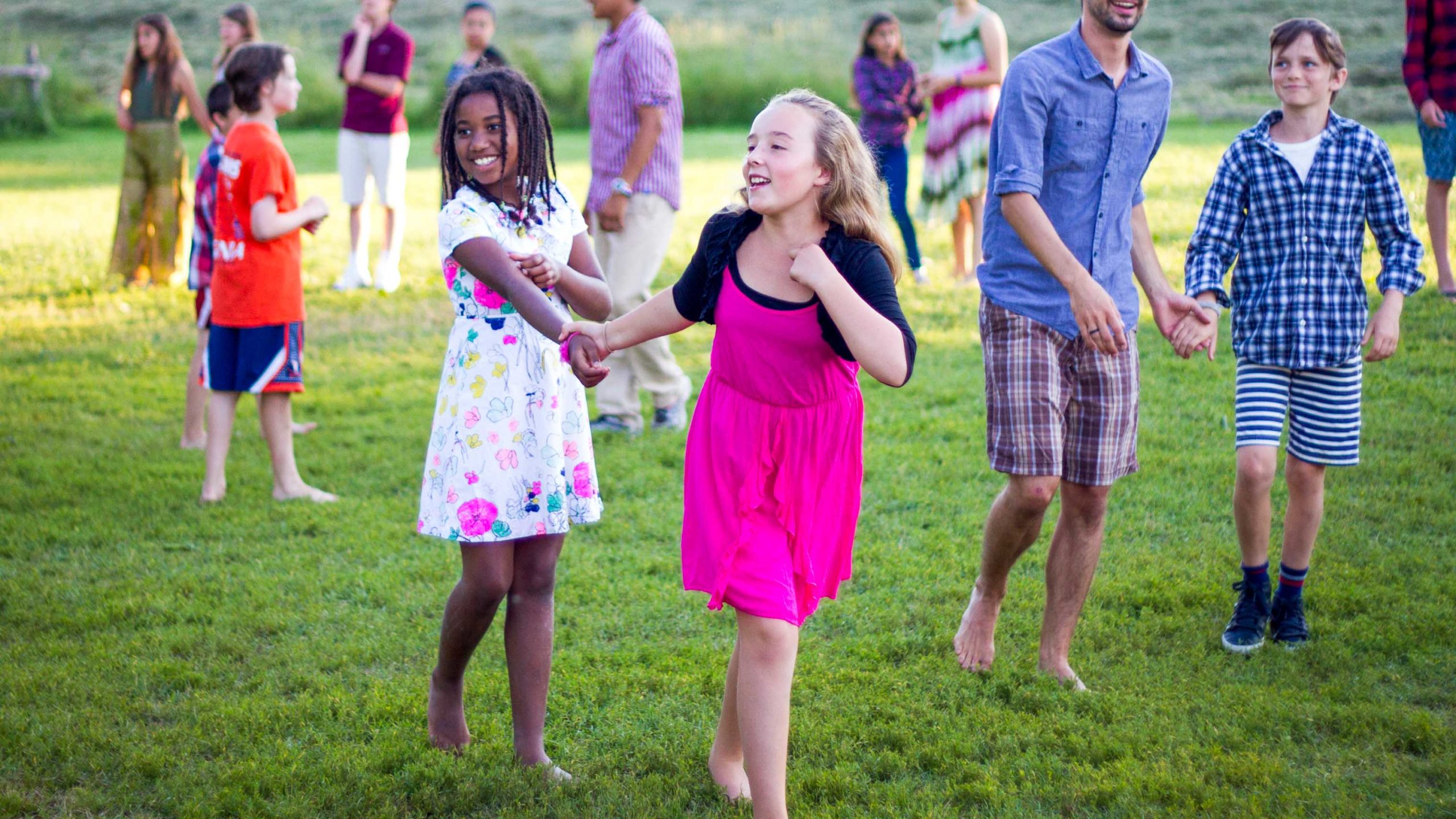 Campers running and having fun in a green field.