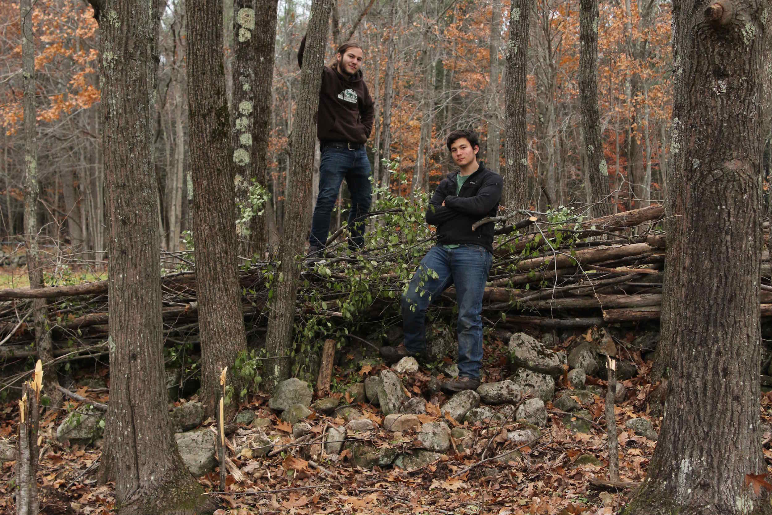 Boah and Sam, two of the “Fencing Four,” and their brush fence they built from trees they felled by hand.