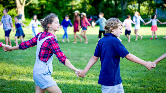 Campers holding hands and walking in a circle.