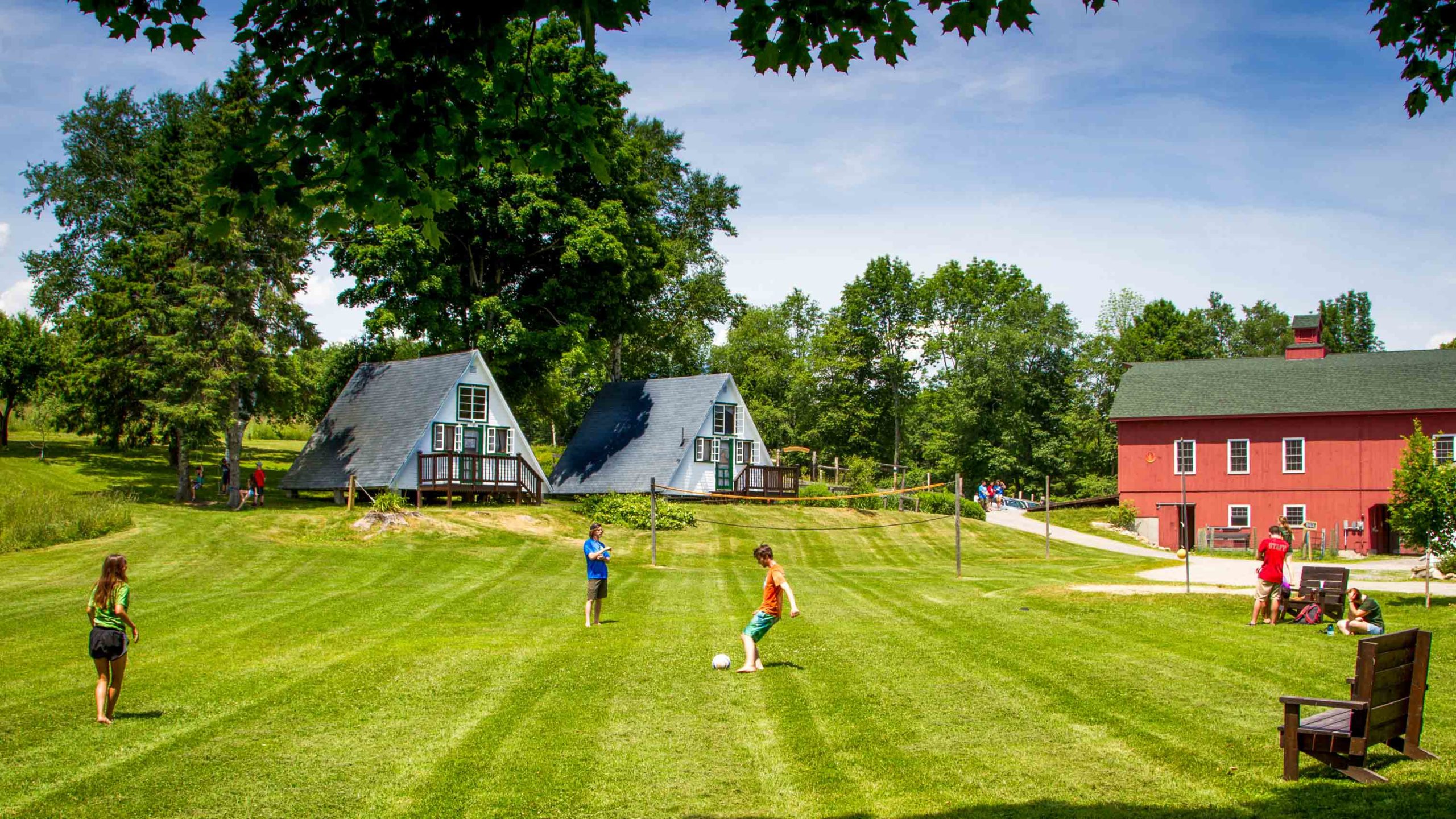 A view of people playing soccer on a green field.