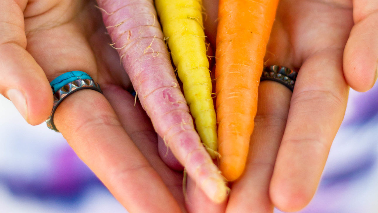 A person holding carrots.