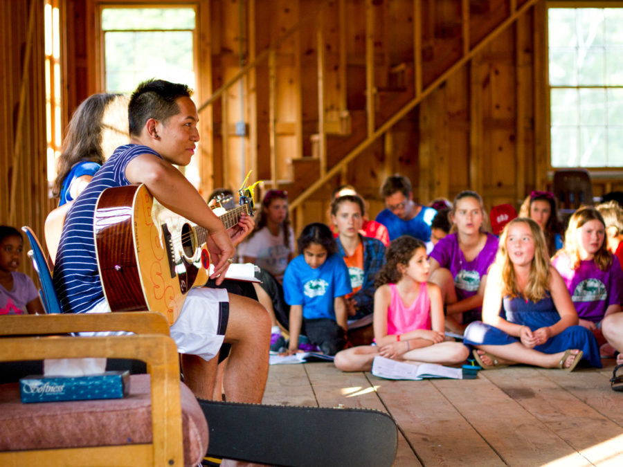 Campers listening to a musical performance.