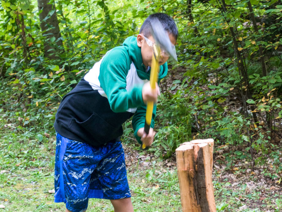 A camper learning how to chop wood