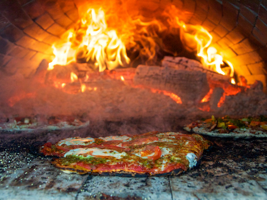 Pizza being baked in a wood oven.