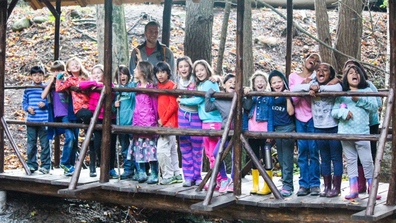 A staff member leading a group of campers on a hike