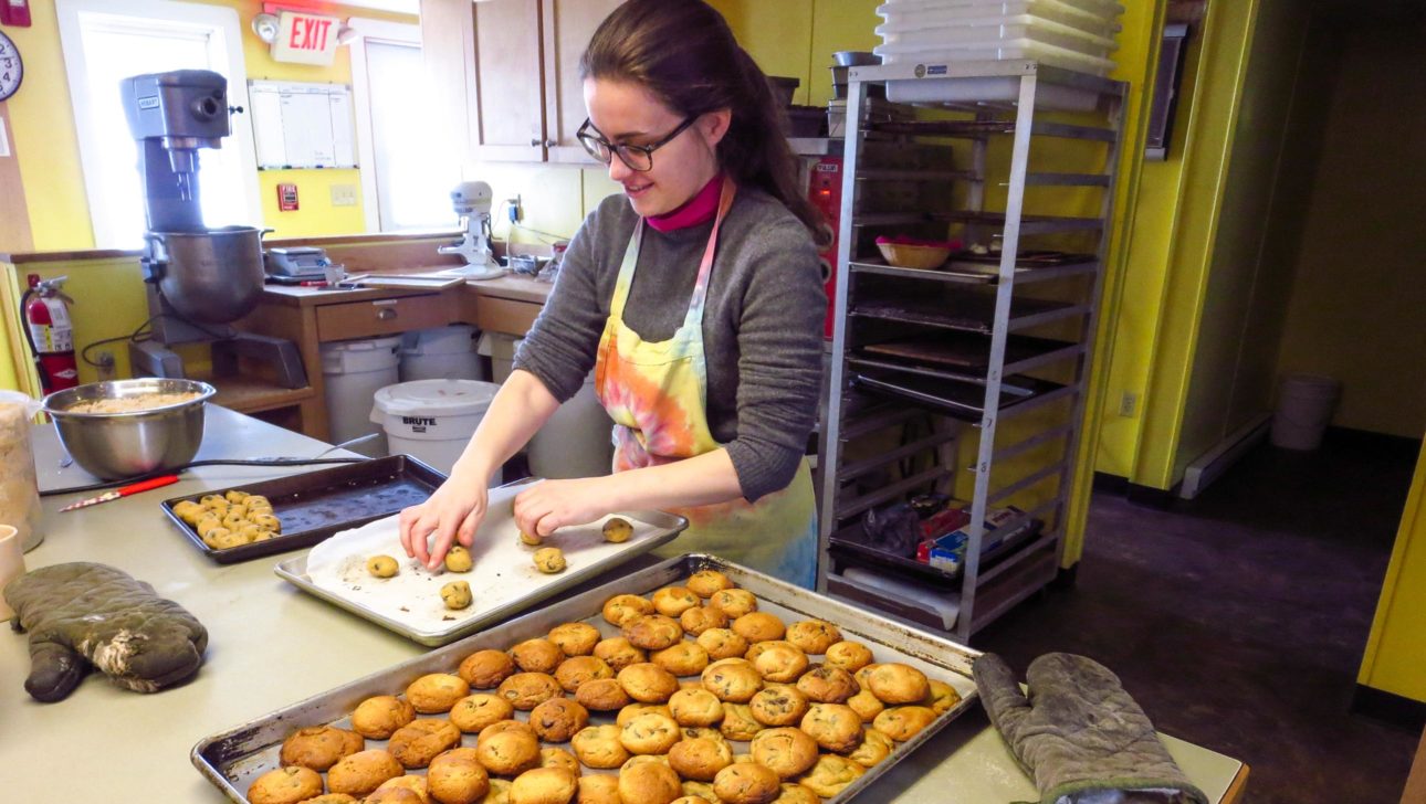 A staff member preparing cookies