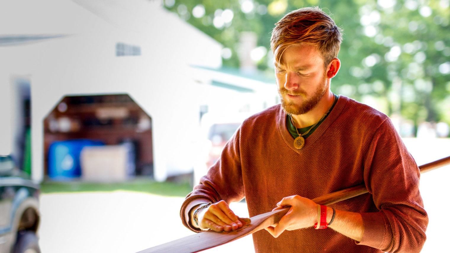 A camper polishing a paddle.