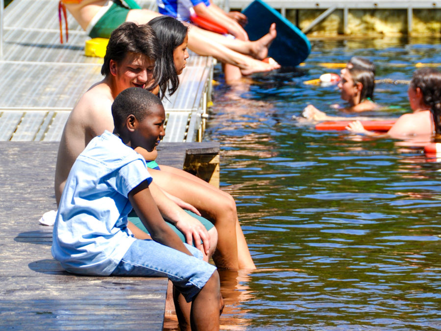 Campers sitting on the dock and talking.