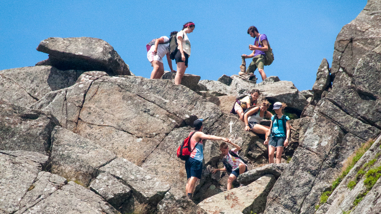 Campers climbing down rocks in the mountains.