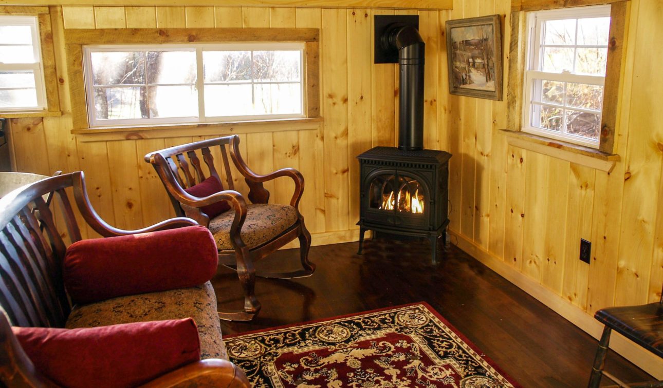 A wood burning stove in the corner of the cottage